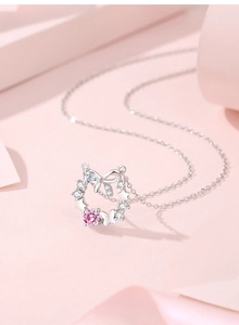 Detailed close-up of S925 silver necklace with pink gemstone star and bow pendant