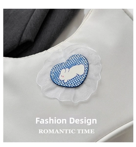 Detail of white cloth handbag featuring a blue plaid heart and lace rabbit patch