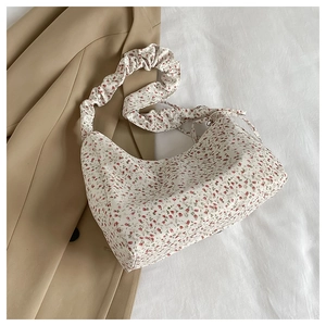 Floral underarm bag detail with drawstring pleated straps on a white background