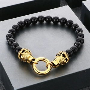 Détail d'un bracelet hip hop en perles de verre noires avec motifs têtes de mort