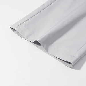 Detailed view of light gray straight trousers hem with fine fabric texture and neat stitching