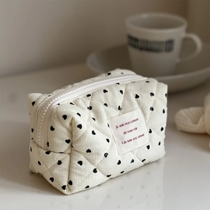 Quilted corduroy mini storage pouch with black heart print and a white top zipper closure