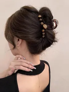 Detailed view of a dark tortoiseshell resin hair claw clip for elegant updo styling