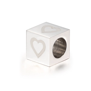 Macro detail of silver cube bead with heart engraving and hole for DIY jewelry