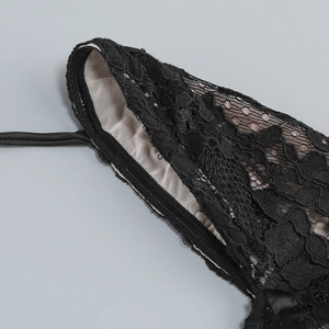 Détail de la broderie en dentelle noire et du tissu en maille respirante sur une robe corset
