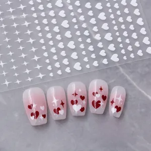 Detail of red and white heart nail stickers on natural gradient artificial nails