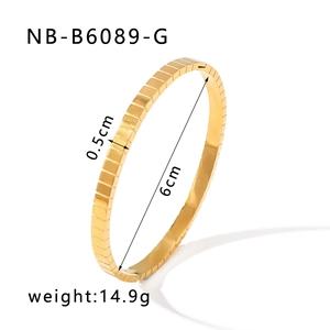 Détail macro du bracelet doré de 0,5 cm de large avec motif texturé de cubes de glace