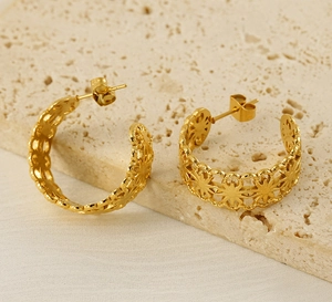 Detail of gold-plated stainless steel hoop earrings with hollow geometric floral patterns