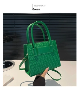 Detail einer grünen Stepptasche mit Rautenmuster und runden Tragegriffen im Fokus