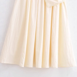 Chic beige pleated cotton skirt with delicate lace trim detail for a feminine fashion look