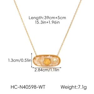 Macro shot of gold stainless steel necklace pendant with shell inlay and scallop design