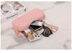 Vue détaillée du vanity rose matelassé avec nœud doré et accessoires de maquillage