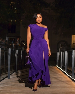 Detail of elegant purple off-shoulder evening dress with high slit and pleated fabric