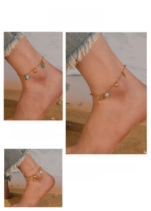 Detail of beach style anklets with turquoise beads and shell dolphin charms on a leg