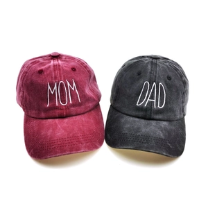 Detail of washed cotton baseball caps with Mom and Dad embroidery in burgundy and grey