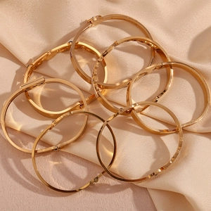 Macro shot of 18K gold plated stainless steel bracelets on silk luxury fabric