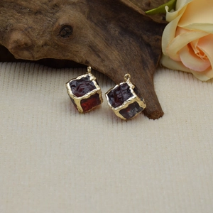 Macro detail of wine red square resin pendants with irregular gold foil edges for DIY jewelry