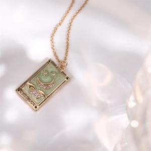 Dettaglio della collana tarocchi in oro con pendente luna, smalto verde e cristalli