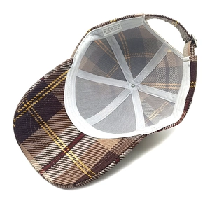 Detailed interior of plaid baseball cap showing sweatband and 100% polyester label