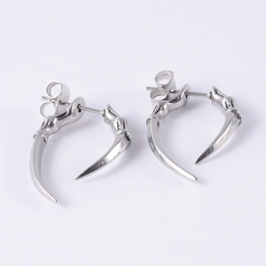 Detailed view of silver stainless steel claw stud earrings set on a white background