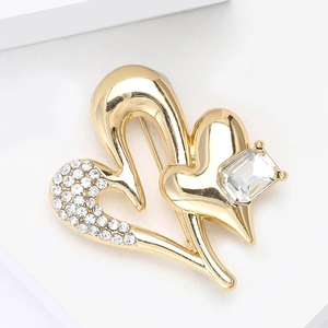Close-up of gold heart brooch featuring a rectangular crystal and pavé rhinestones