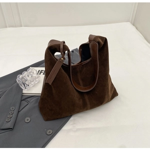 Detail of dark brown suede patchwork tote with soft texture and shoulder strap