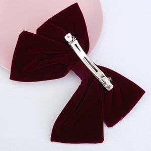 Large red velvet bow hair clip with silver clip and elegant flowing ribbon strands