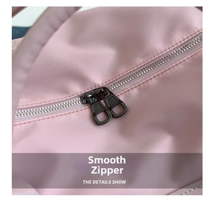 Close-up of durable dual smooth metal zippers on pink waterproof yoga fitness bag
