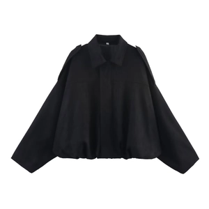 Détail d'une veste noire en velours avec col rabattu et manches larges amples