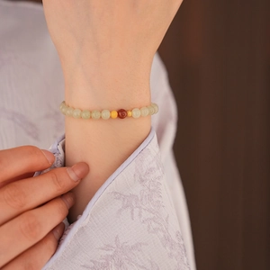 Detailed close-up of a beaded bracelet with jade, amber, and agate on a female wrist