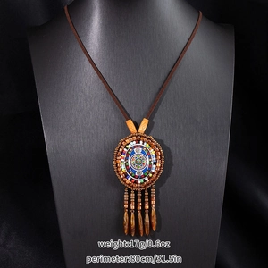 Detail of bohemian tassel necklace with colorful beads and patterned pendant on mannequin