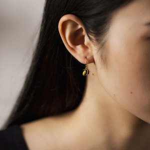 Macro shot of 925 sterling silver bee earring with gold hooks and enamel details