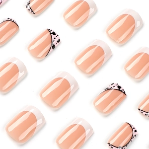 Pink and white French press-on nails with black heart dots and glitter finish