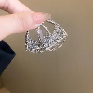 Silver fringe chain earrings with sparkling zircon accents shown in a close-up hand view