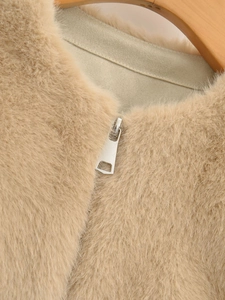 Dettaglio del gilet in ecopelliccia beige con consistenza morbida e cerniera in metallo