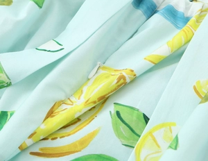 Detail of hidden white zipper on light blue poplin dress with yellow lemon print