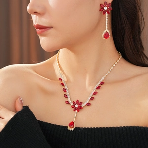 Detailed view of luxury gold jewelry set with vibrant red teardrop zircon stones