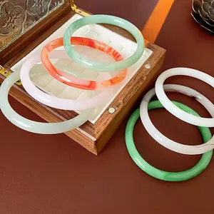 Minimalist round resin bangles in pastel colors displayed on a vintage jewelry box