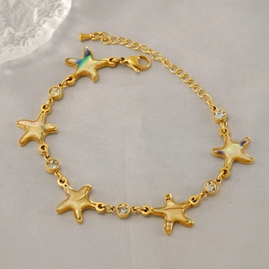Detailed view of gold starfish bracelet with colorful inlay and clear zircon accents