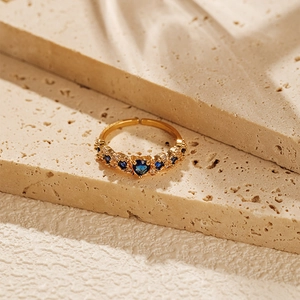 Macro shot of 18K gold plated heart ring with blue zircon and white crystal accents