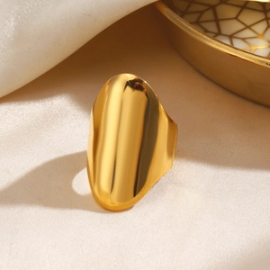 Bague large bombée en acier inoxydable doré poli sur fond de soie blanche élégante