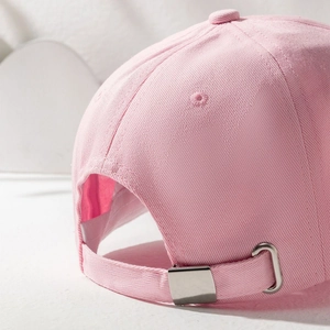 Detail of light pink cotton baseball cap featuring an adjustable silver metal slider buckle