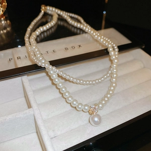 Detail view of double-layer pearl necklace with zircon pendant in jewelry box