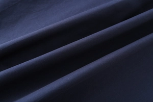 Macro shot of dark blue cotton poplin fabric texture showing detailed fiber weaving