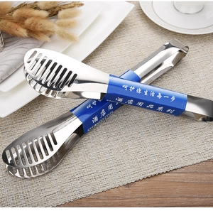 Macro shot of stainless steel food tongs with slotted design for oil draining in kitchen