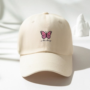 Minimalist beige cotton baseball cap featuring butterfly print and be the change text