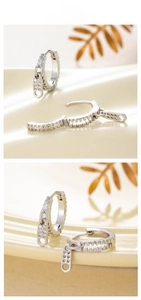 Macro shot of silver zipper shape huggie earrings with cubic zirconia inlay details