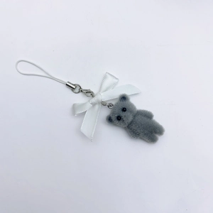 Cute grey flocked bear keychain with white ribbon bow and lanyard on white background