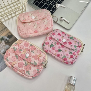 Detailed shot of quilted floral and puppy mini pouches with metal ring for organization