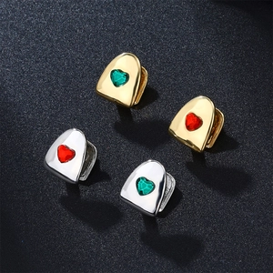 Detailed view of single tooth gold and silver hip hop grillz with heart stones